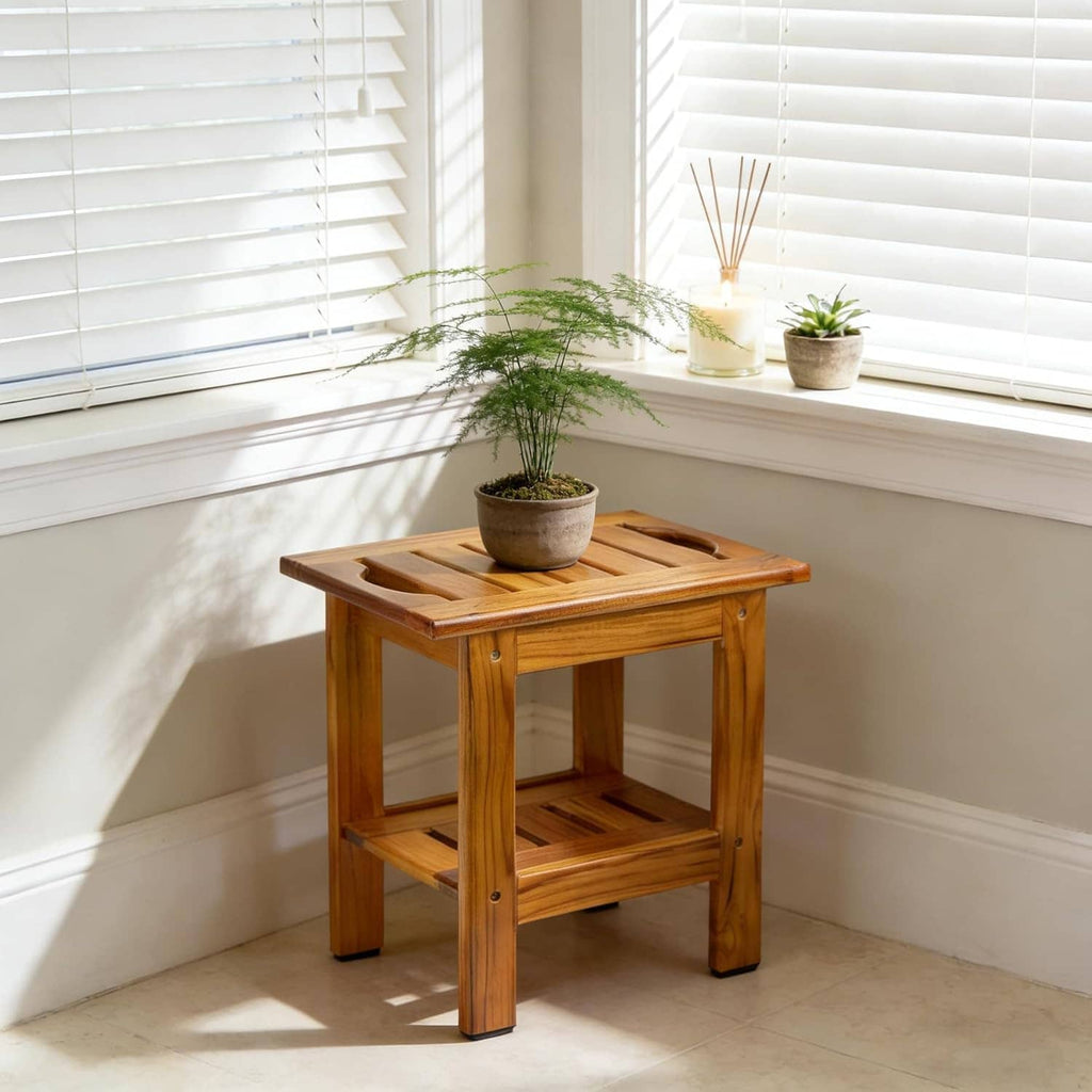 Teak slatted shower stool with lower shelf, used as a small plant stand