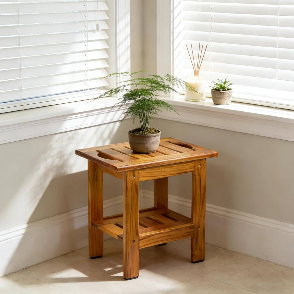 Teak slatted shower stool with lower shelf, used as a small plant stand