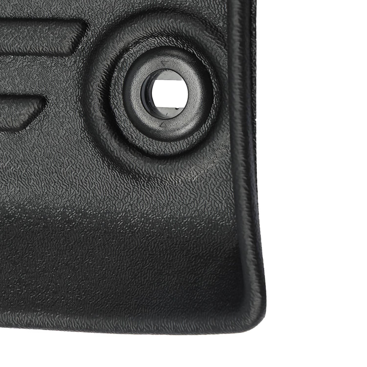 Close-up of black textured TPE floor mat surface with circular fastener opening