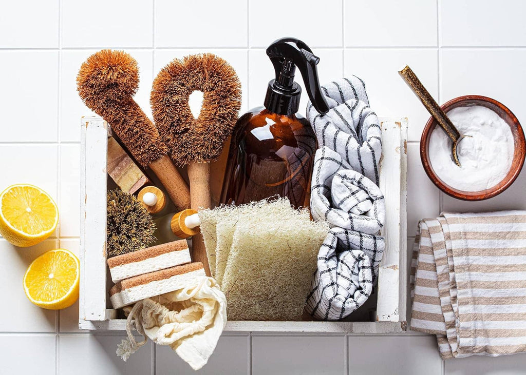 Cleaning caddy with two scrub brushes, spray bottle, cloth, and lemon halves
