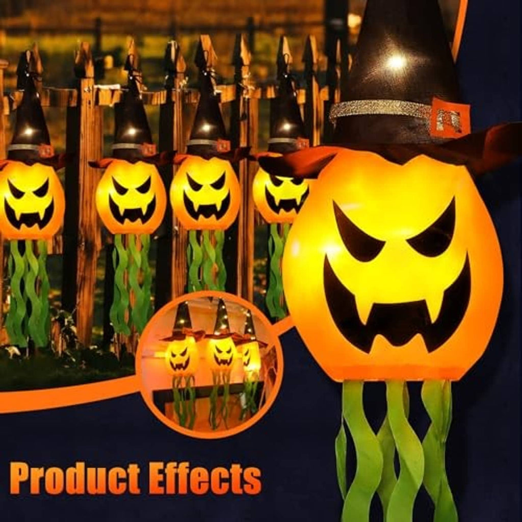 Large glowing jack-o’-lantern pumpkin with black witch hat hanging light and green tentacles