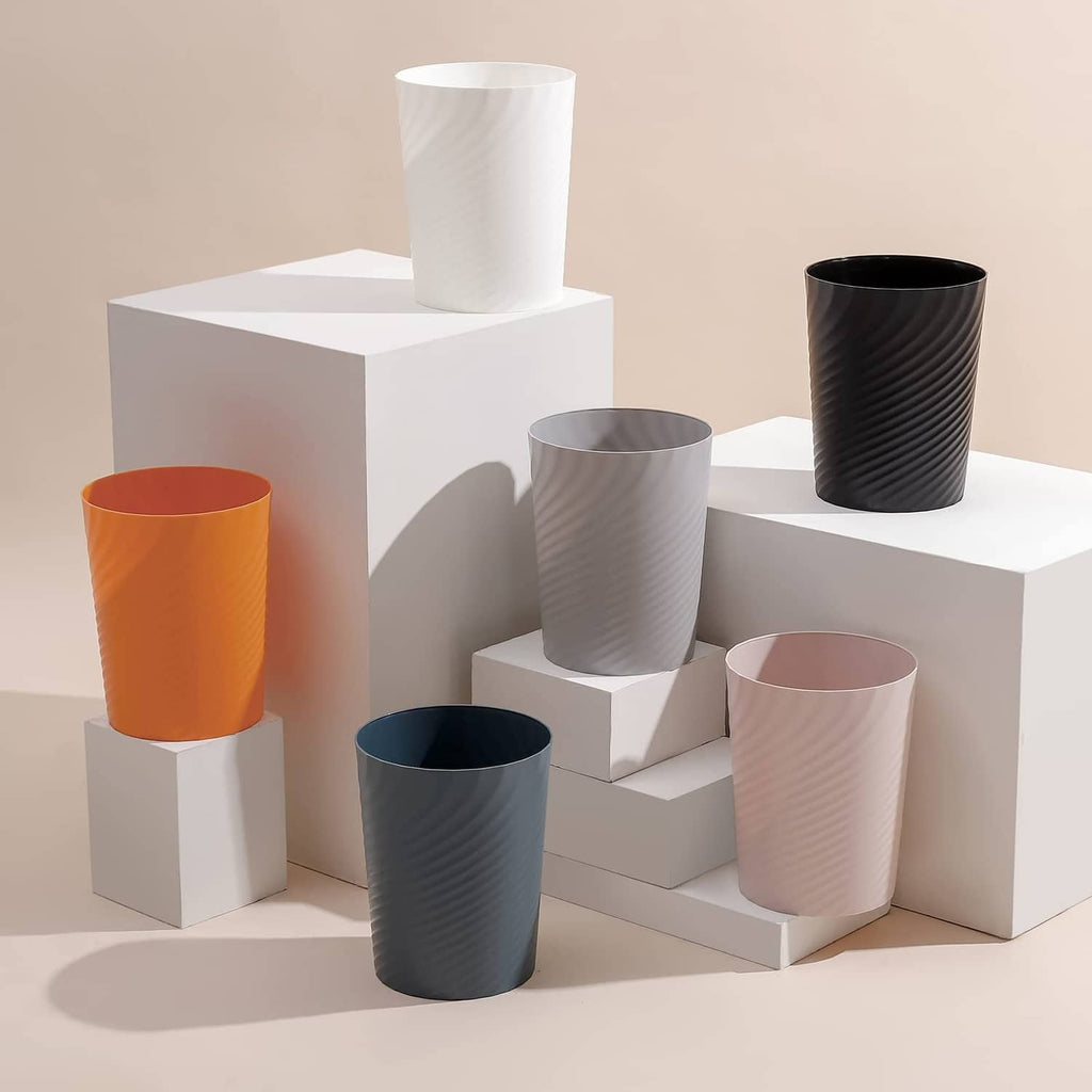 Assorted color plastic trash cans with ribbed sides and open tops