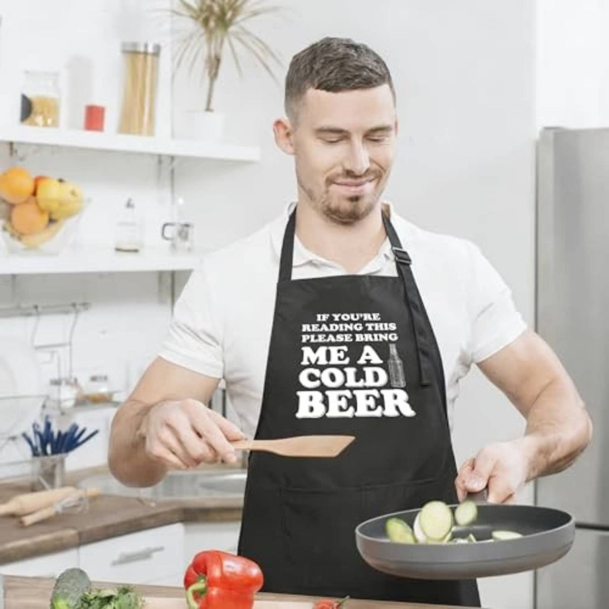 Black kitchen apron with 'me a cold beer' slogan and two front pockets