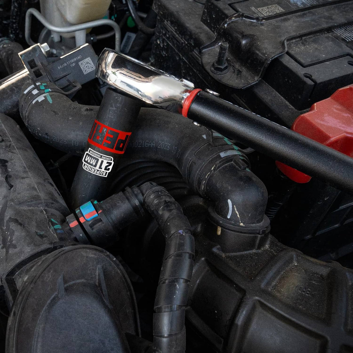 1/2-inch drive impact socket tools in use near engine hoses and wiring