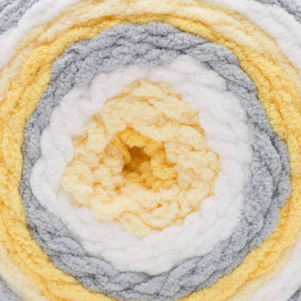 Self-striping yarn close-up with gray, white, and yellow circular pattern