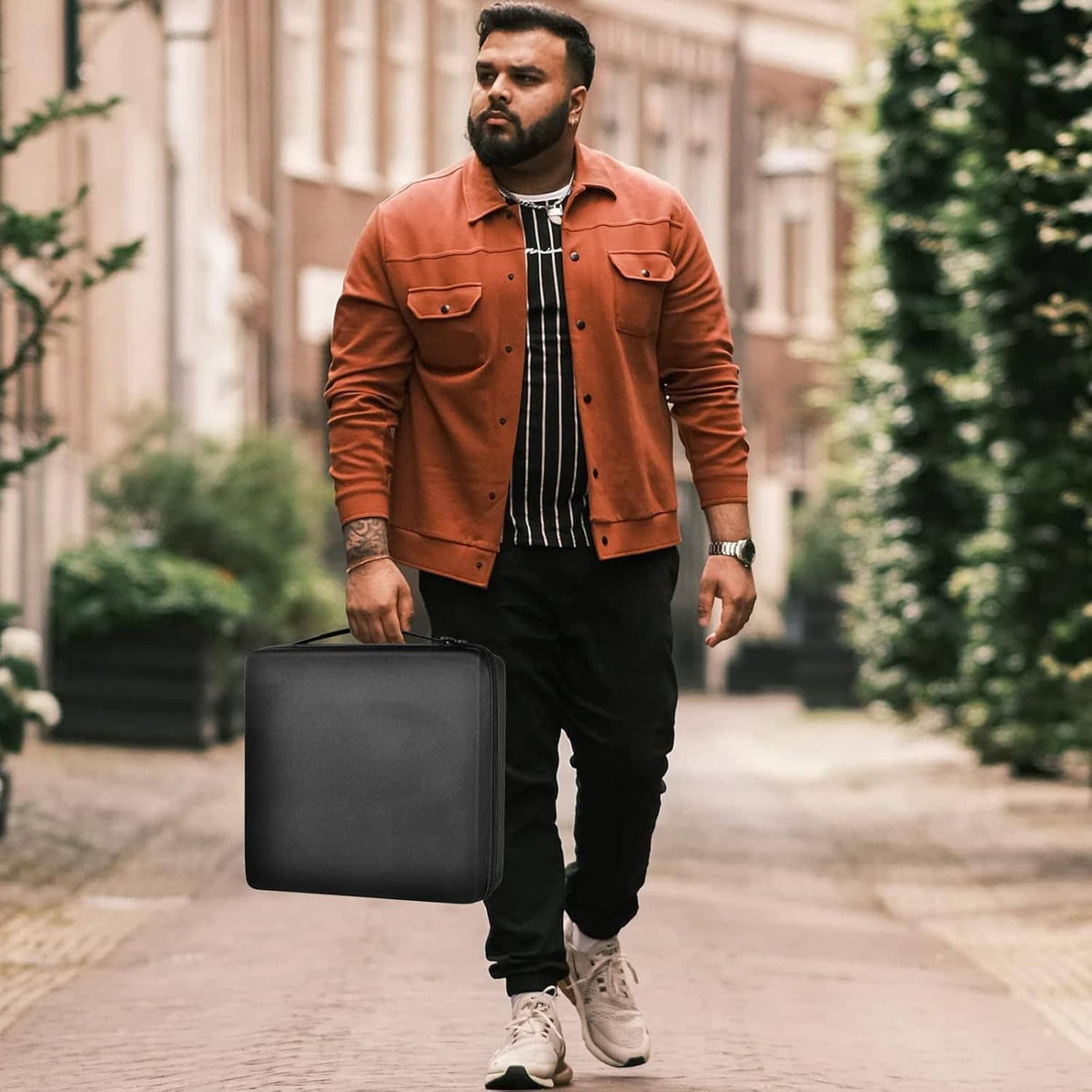 Black square watch storage case being carried