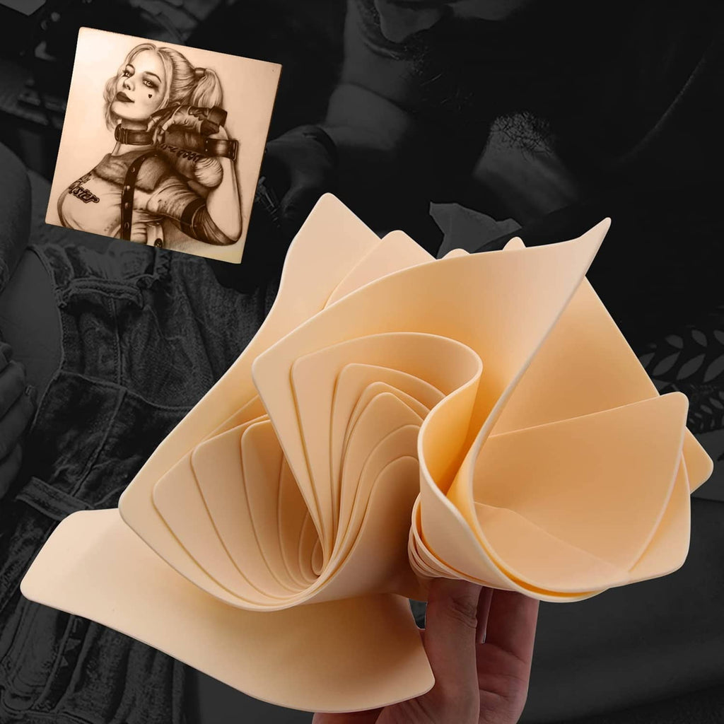 Beige tattoo practice skin pads, folded stack held in hand for practice