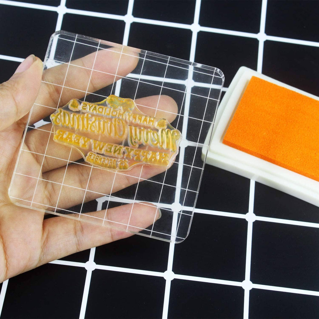 Clear acrylic stamp block with grid lines, holding an inked word design stamp