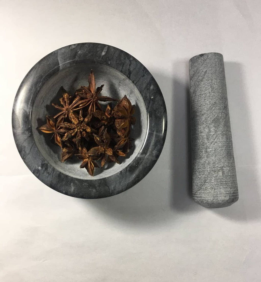 Dark gray pestle replacement next to a mortar bowl with spices
