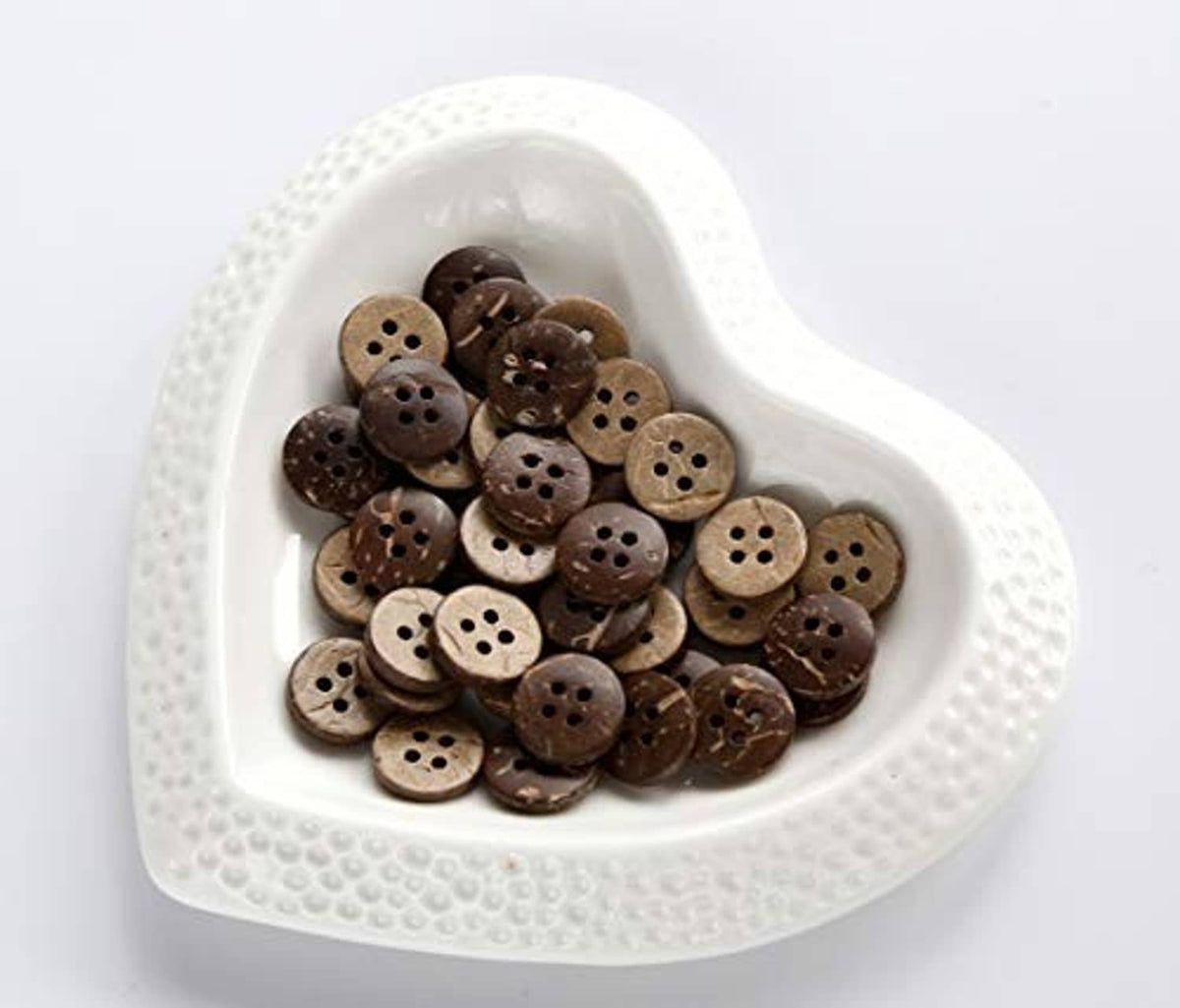 Round 4-hole coconut shell buttons in a white heart-shaped tray