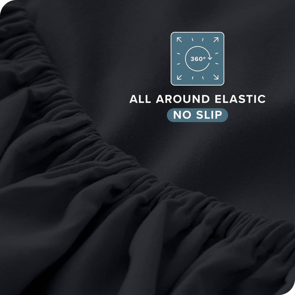 Black fitted sheet corner with gathered elastic edge, close-up fabric texture
