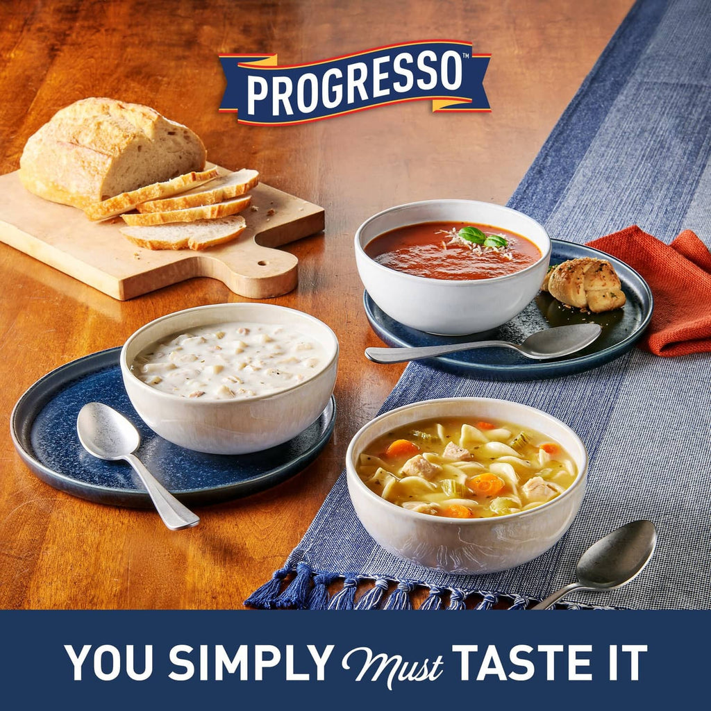 Chicken noodle soup meal with bowls and bread, featuring Progresso can branding