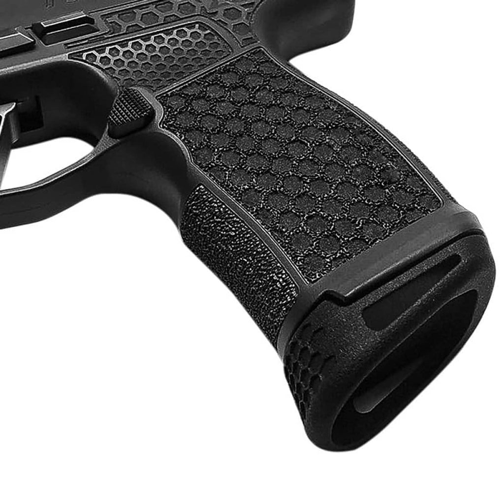 Detail of black hex-pattern grip texture on installed pistol magazine extension