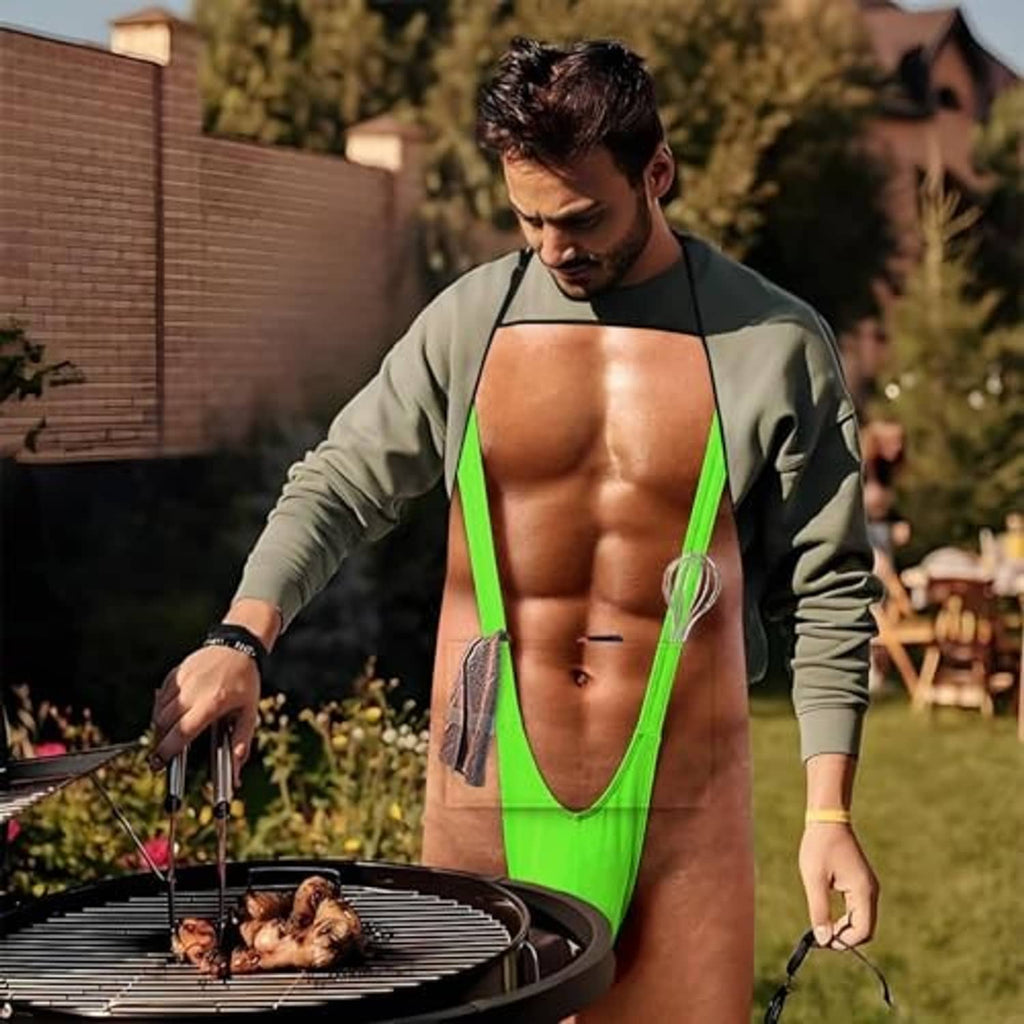 Novelty grilling apron with green trim and printed front worn outdoors, hands on grill tools