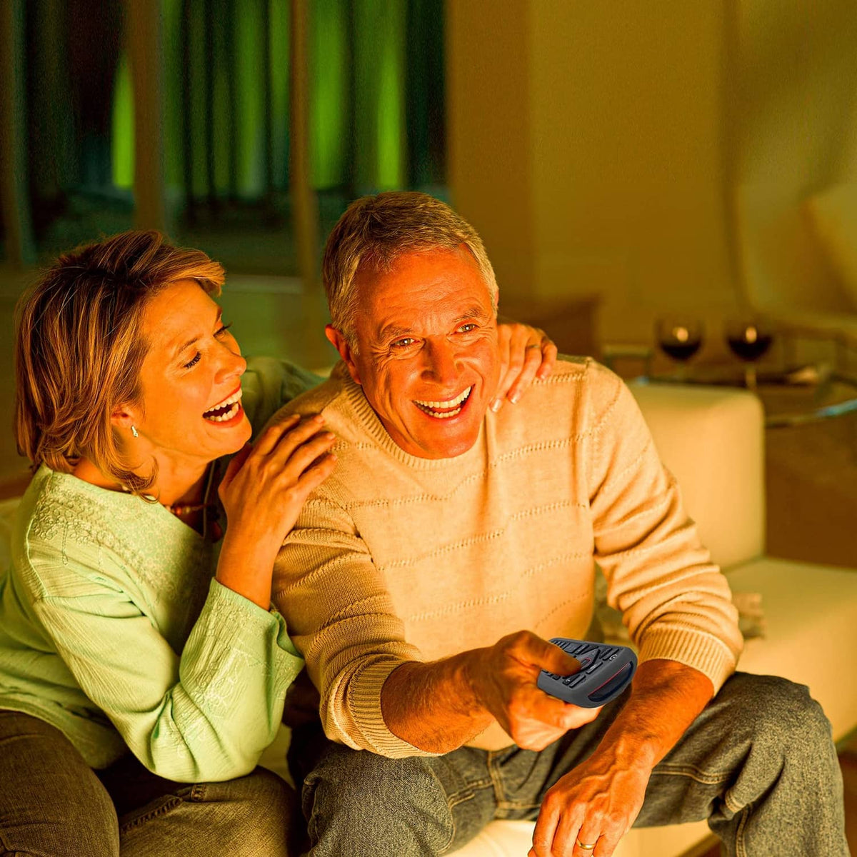 Gray remote control cover held while seated on a couch, slim protective case for TV.