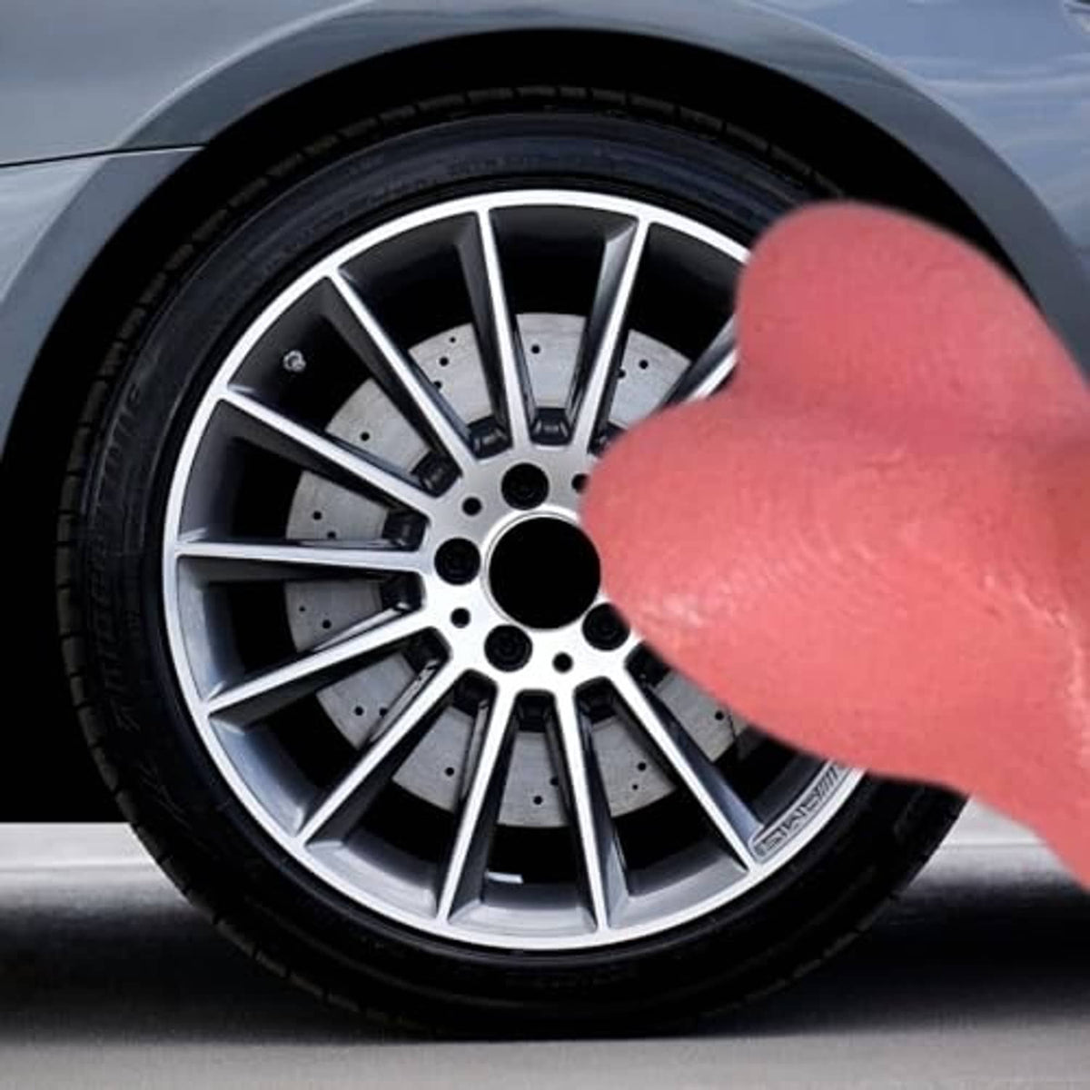 Pink novelty valve stem cap on front wheel rim, inserted into tire valve
