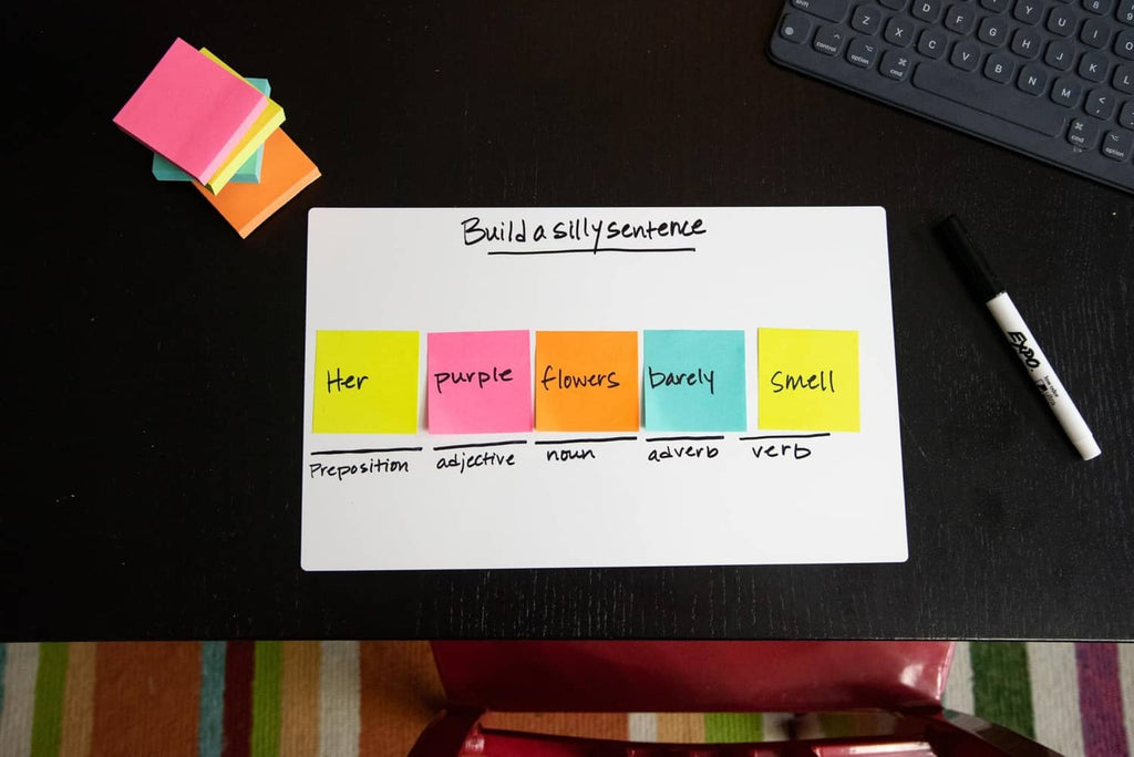 White dry erase sheet titled “Build a silly sentence” with colored labels