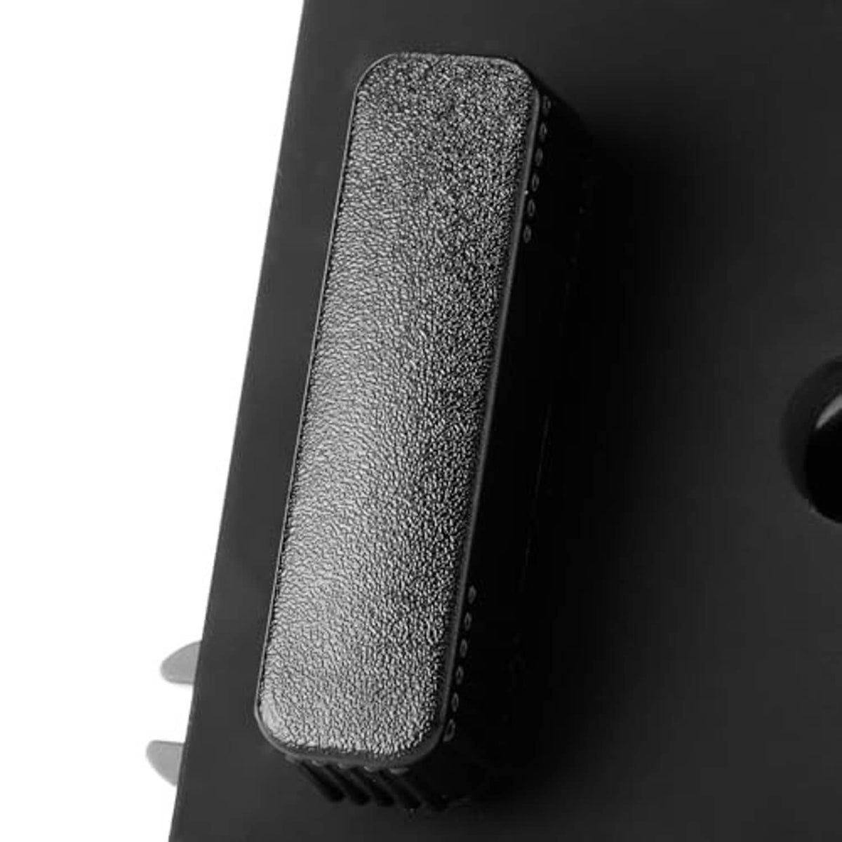 Close-up of textured rocker button on black passenger power seat switch control module.