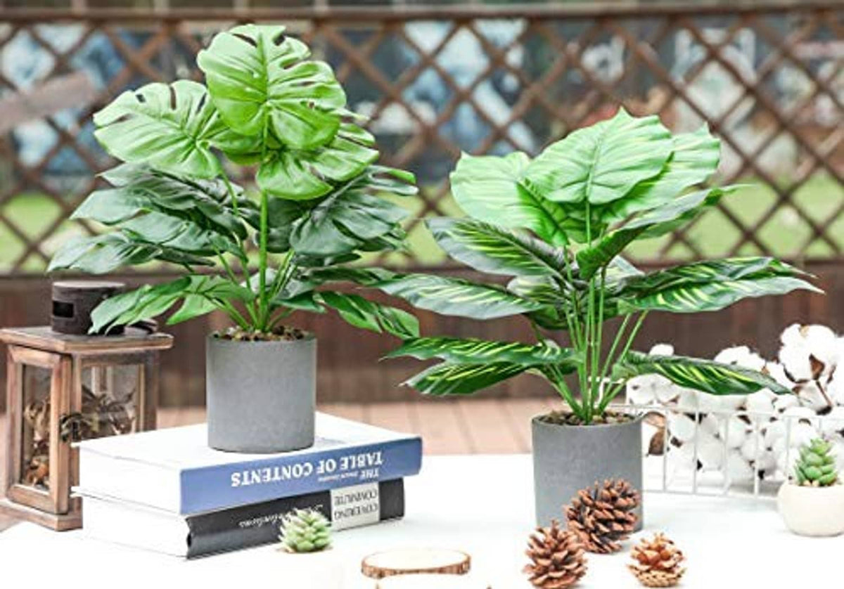 Artificial potted tropical plants in gray pots with vibrant green leaves
