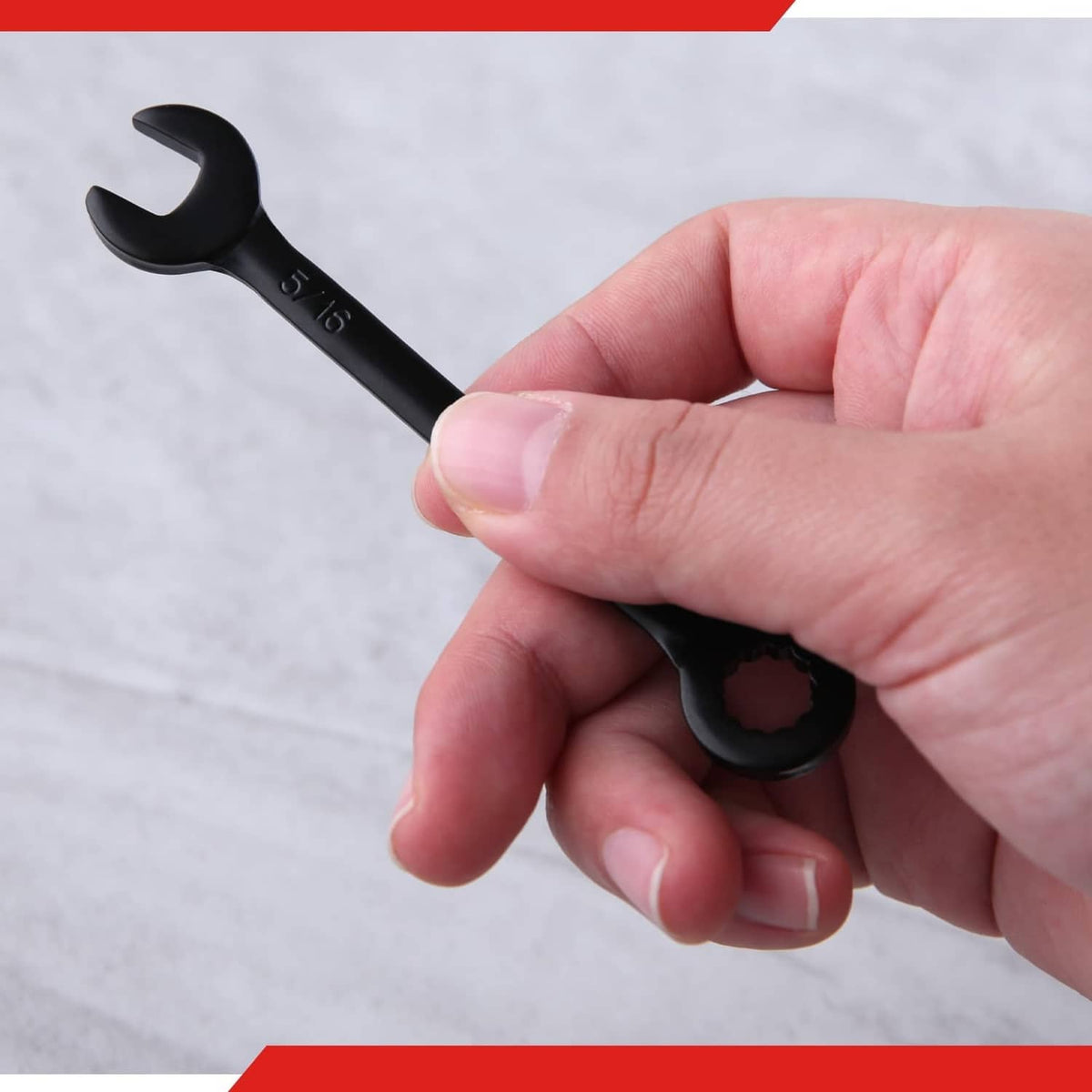 Black mini open-end wrench held in hand, marked SAE sizes
