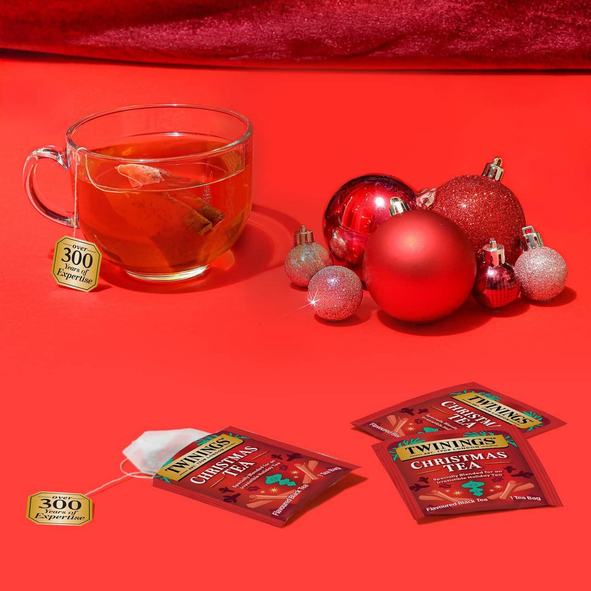 Twinings Christmas Tea red tea bags packs with cup of spiced tea and decorative ornaments.