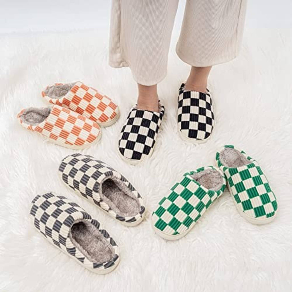 Fuzzy check house slippers on feet: green, orange, and black plaid styles shown
