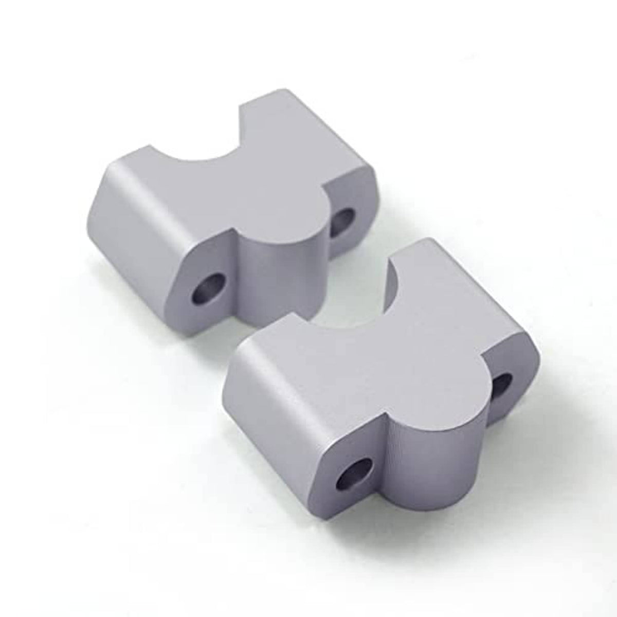 Silver CNC aluminum handlebar riser replacement brackets, angled view showing hole cutouts