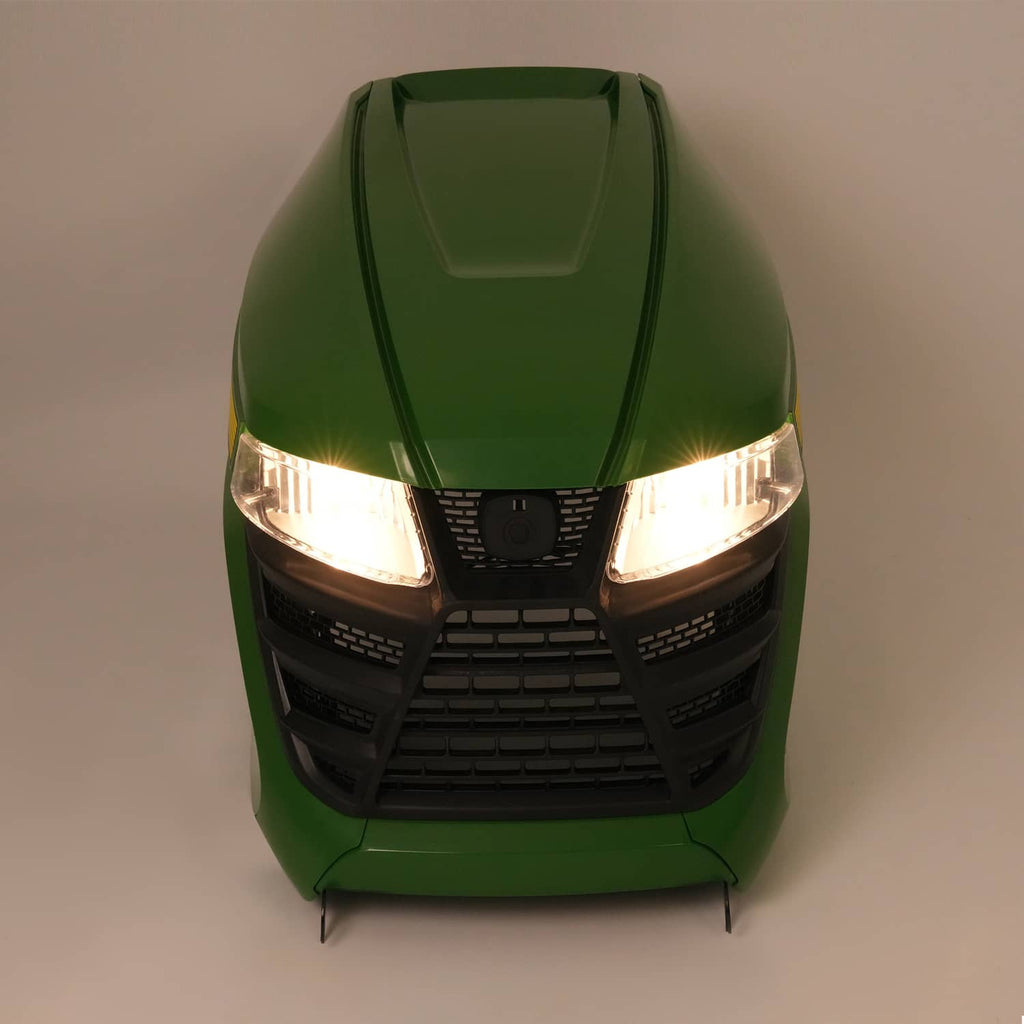 Green lawn tractor front with illuminated headlights and black grille panel