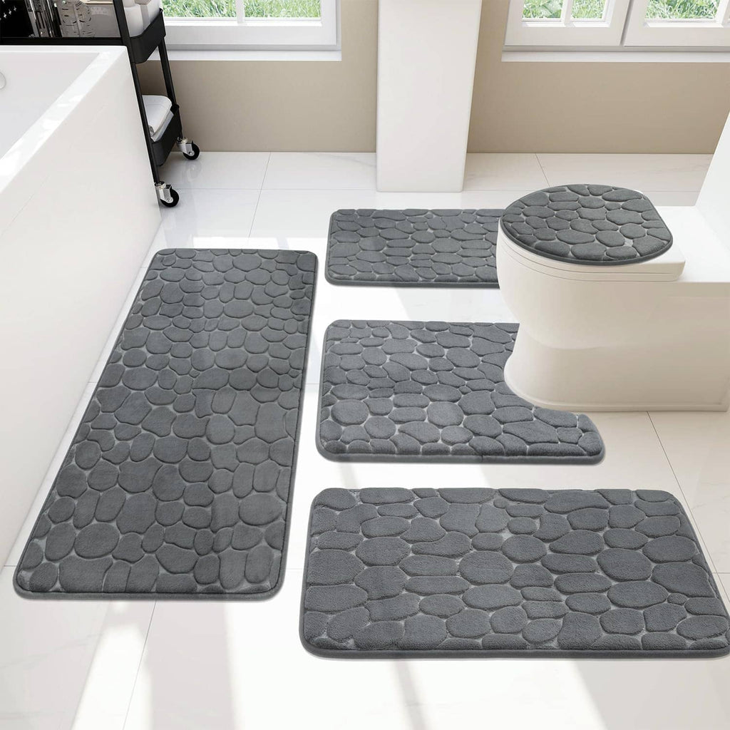 Five-piece dark grey bath rug set featuring pebble-texture mats in a bathroom arrangement
