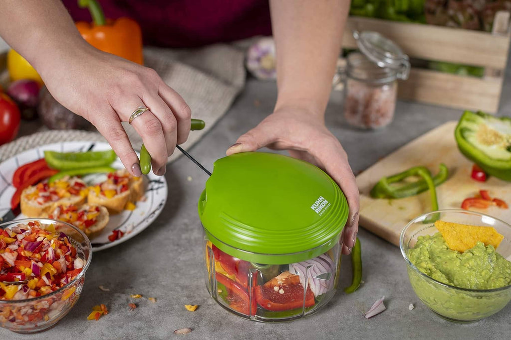 Hands holding a green pull-cord food chopper while ingredients are prepared nearby
