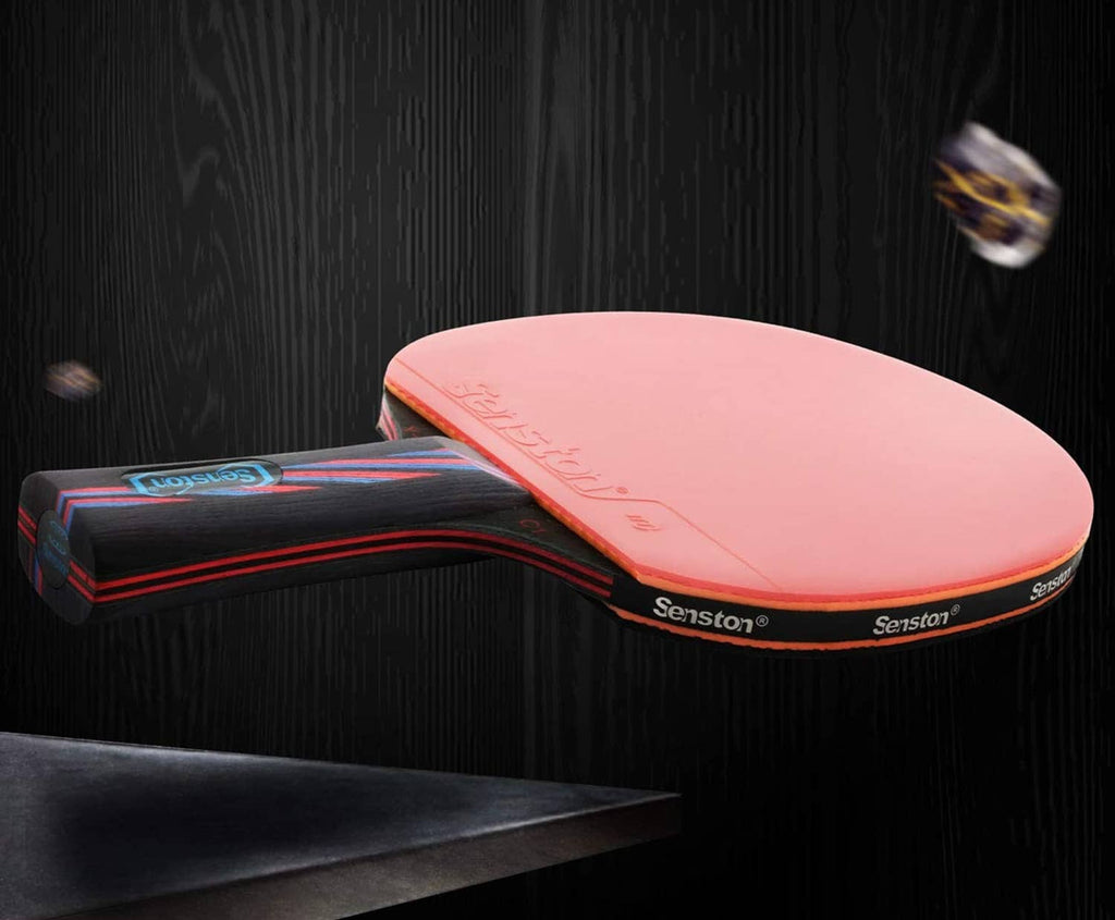 Table tennis paddle with pink rubber face and dark red-black handle