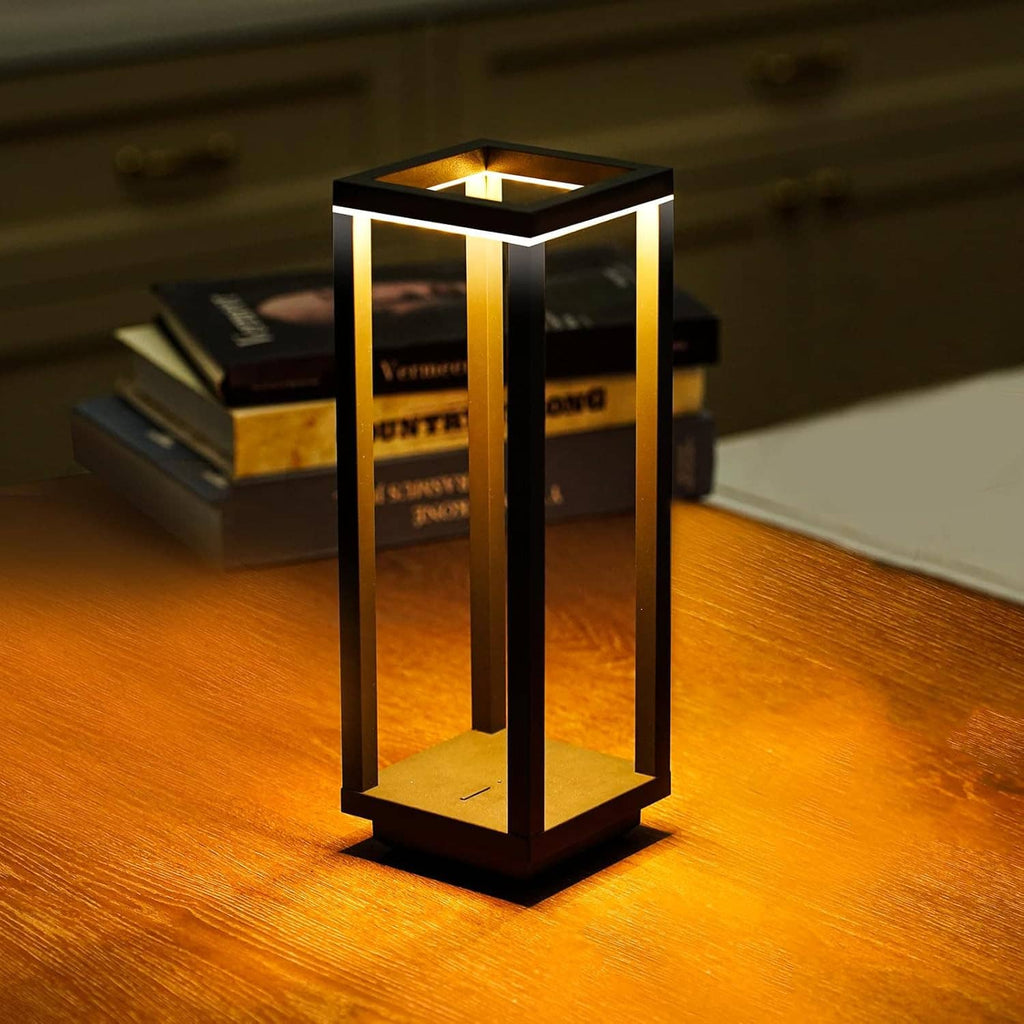 Black metal lantern-style cordless table lamp with warm LED glow, top opening lit