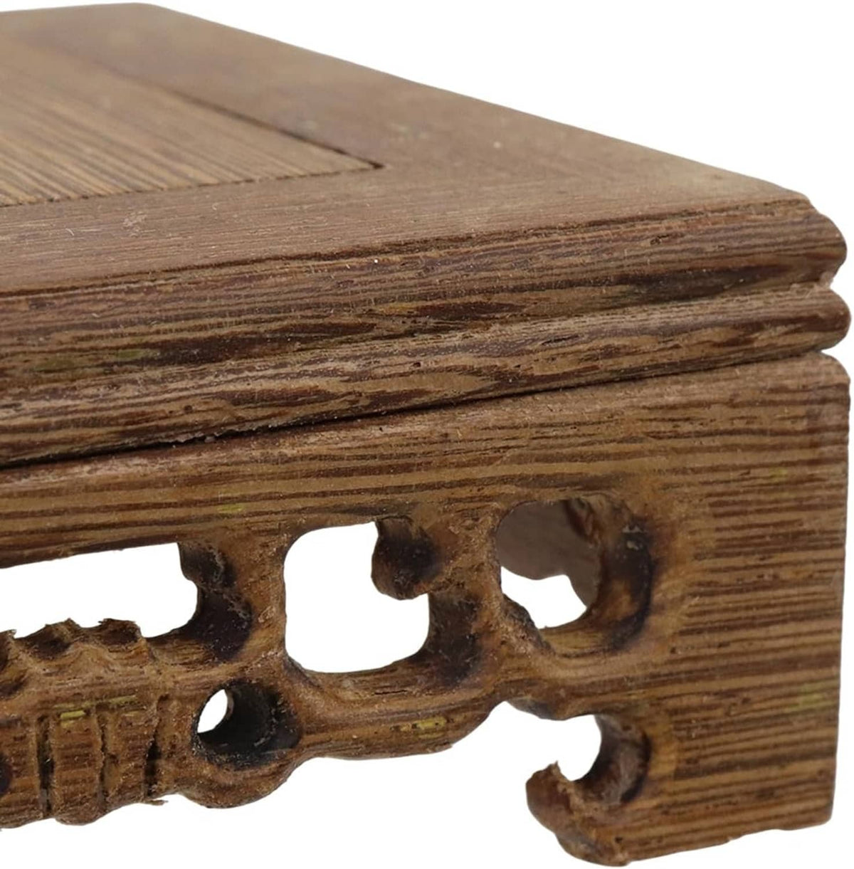 Wooden display stand base close-up of carved side edge and row of oval cutouts