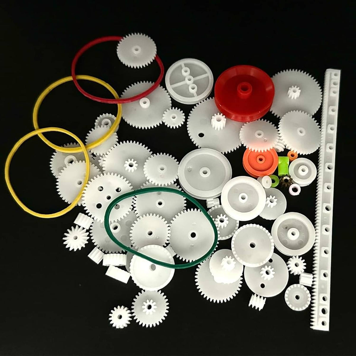 Plastic gear kit with white gears, red and orange pulleys, and green belt loop