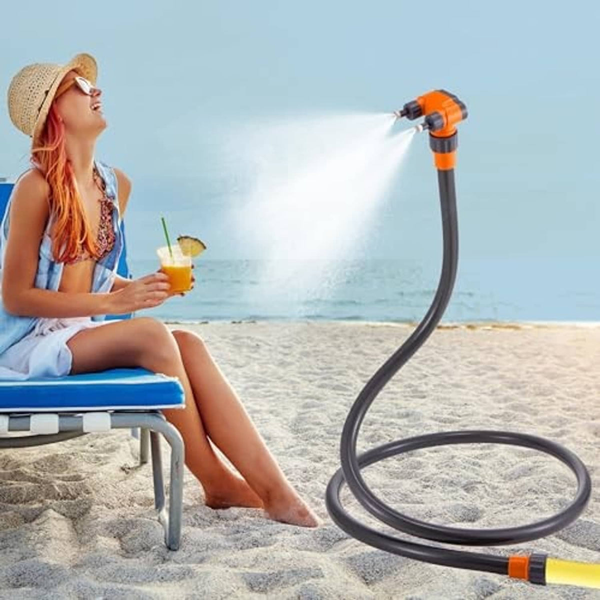 Standing patio misting nozzle with flexible black hose and orange accents, spraying mist