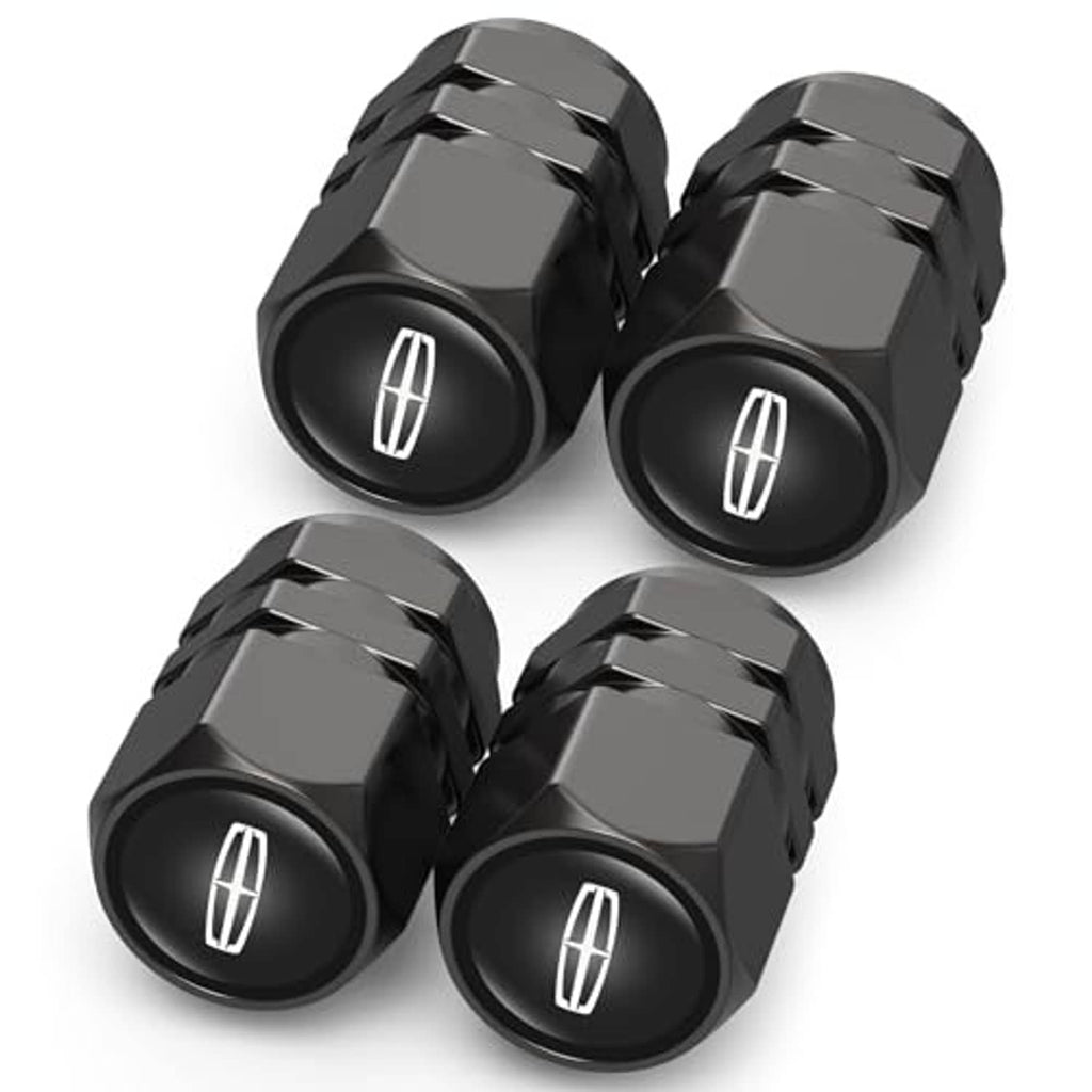 Four black tire valve stem caps with raised hex texture and oval tire symbol