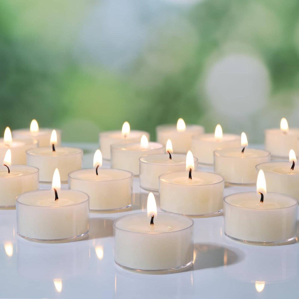 Cream beeswax tea light candles with flames, arranged in rows