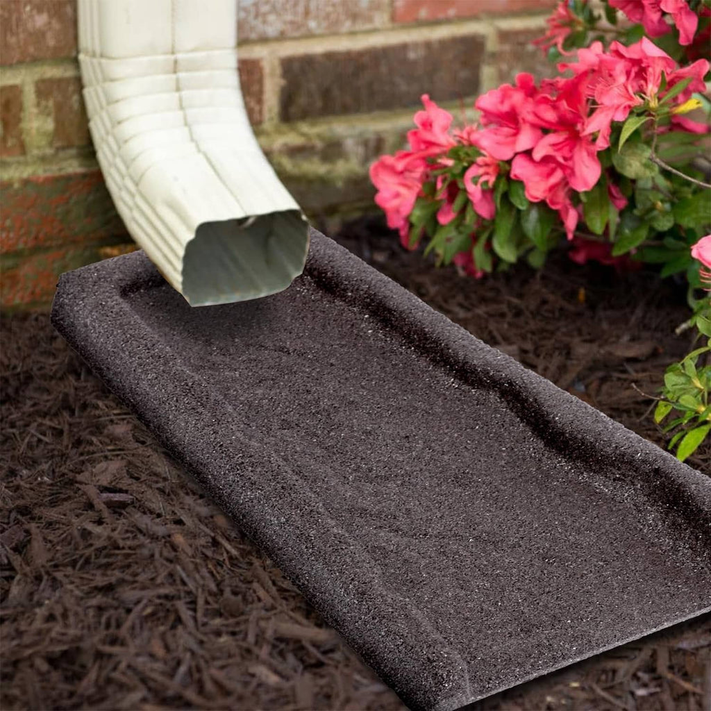 Brown rubber downspout splash block under an extended gutter outlet