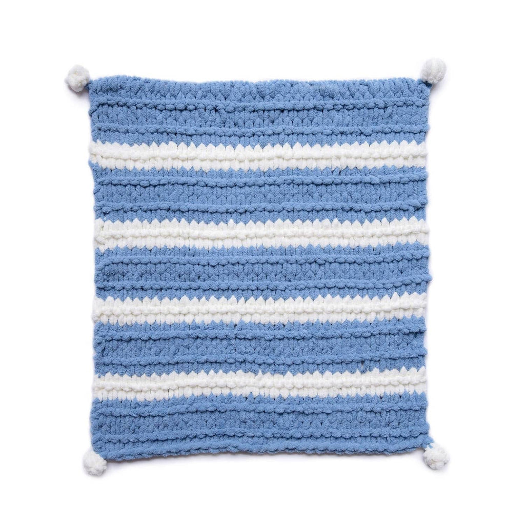 Blue and white striped chunky knit square blanket with pom-pom corners