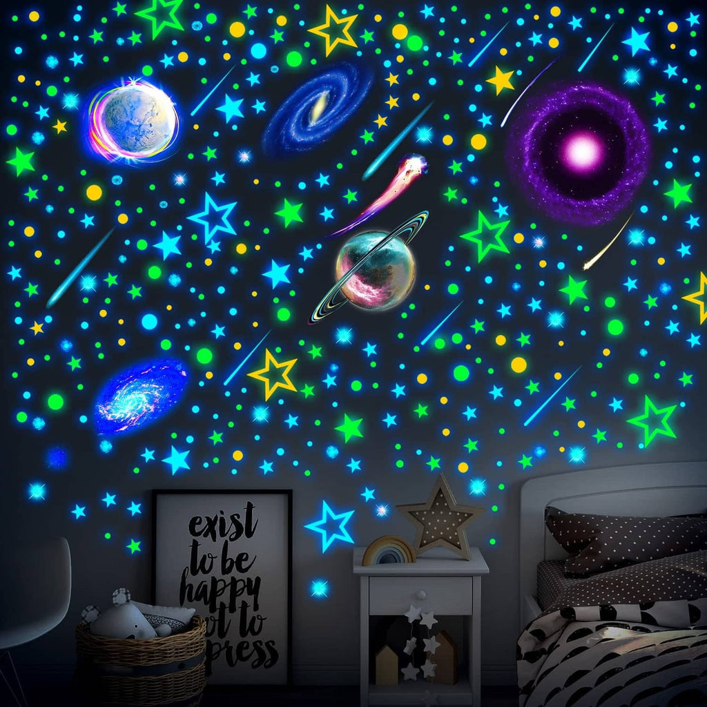 Glow-in-the-dark space star and planet wall decals on a bedroom wall with scattered icons
