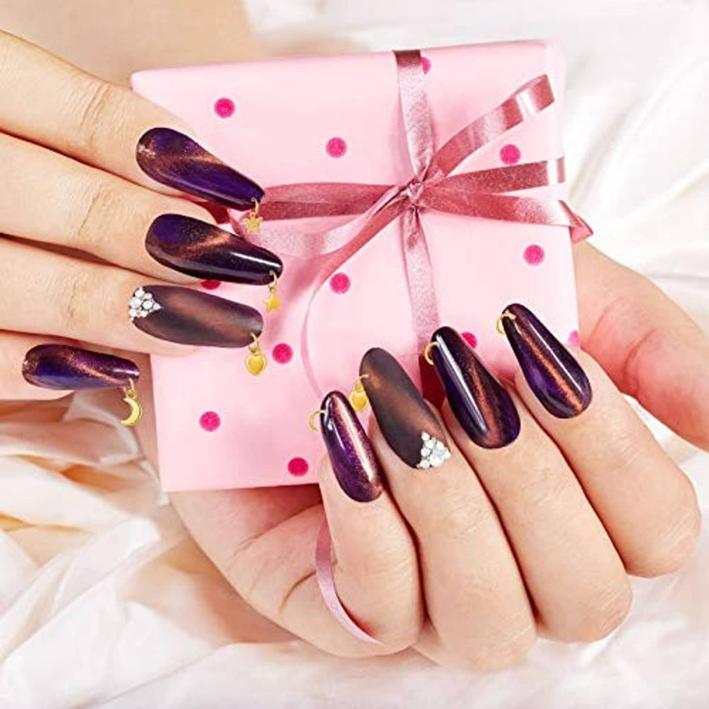 Nail jewelry rings set with gold crescent and heart charms on long dark press-on nails