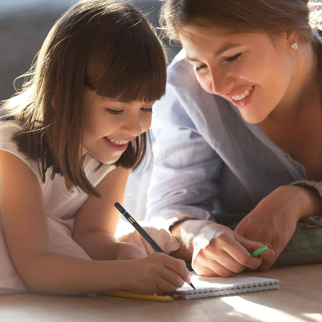 Children drawing with charcoal pencils, creating a picture in sketchbooks