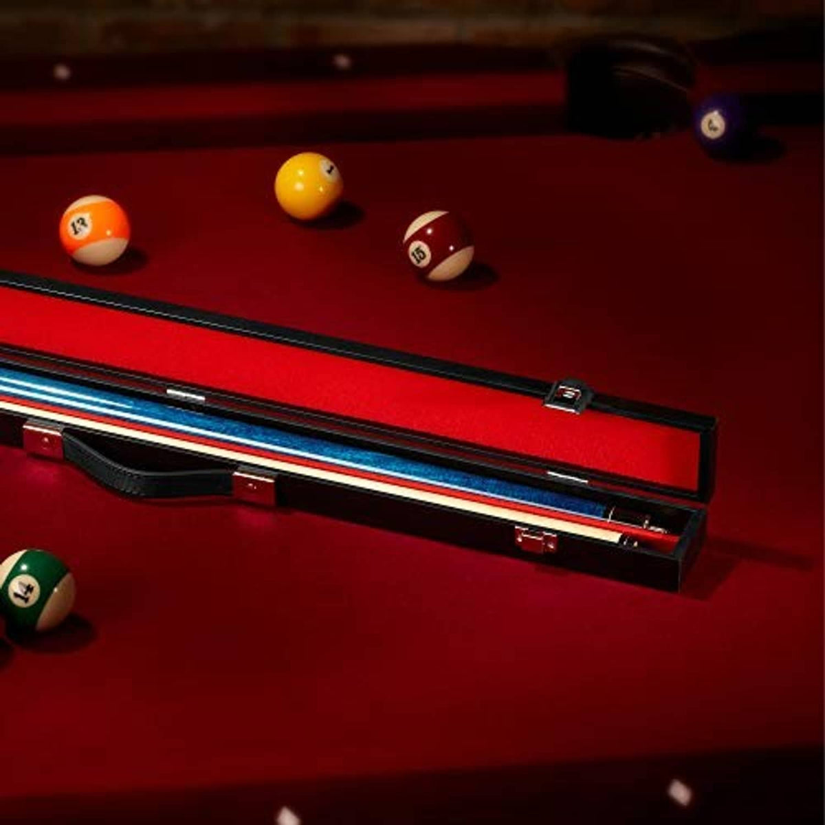 Black billiard cue hard case with red lining on a pool table