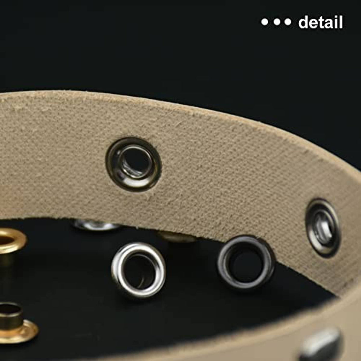 Close-up of grommet eyelets on beige fabric with metal ring fasteners
