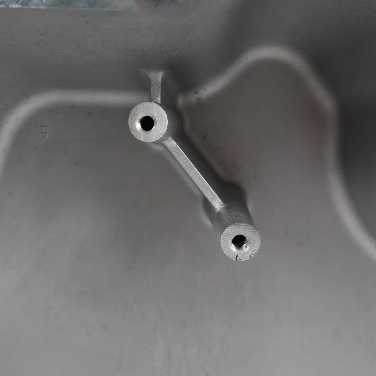 Oil pan interior showing metal support brackets and round holes