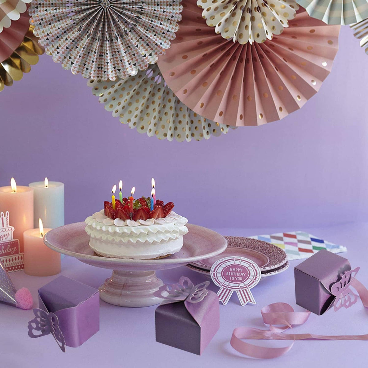 Purple butterfly favor boxes with matching butterfly cutout gift tags on a table
