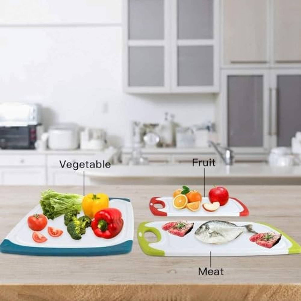 Four color-coded plastic cutting boards on a kitchen counter with vegetables and fish