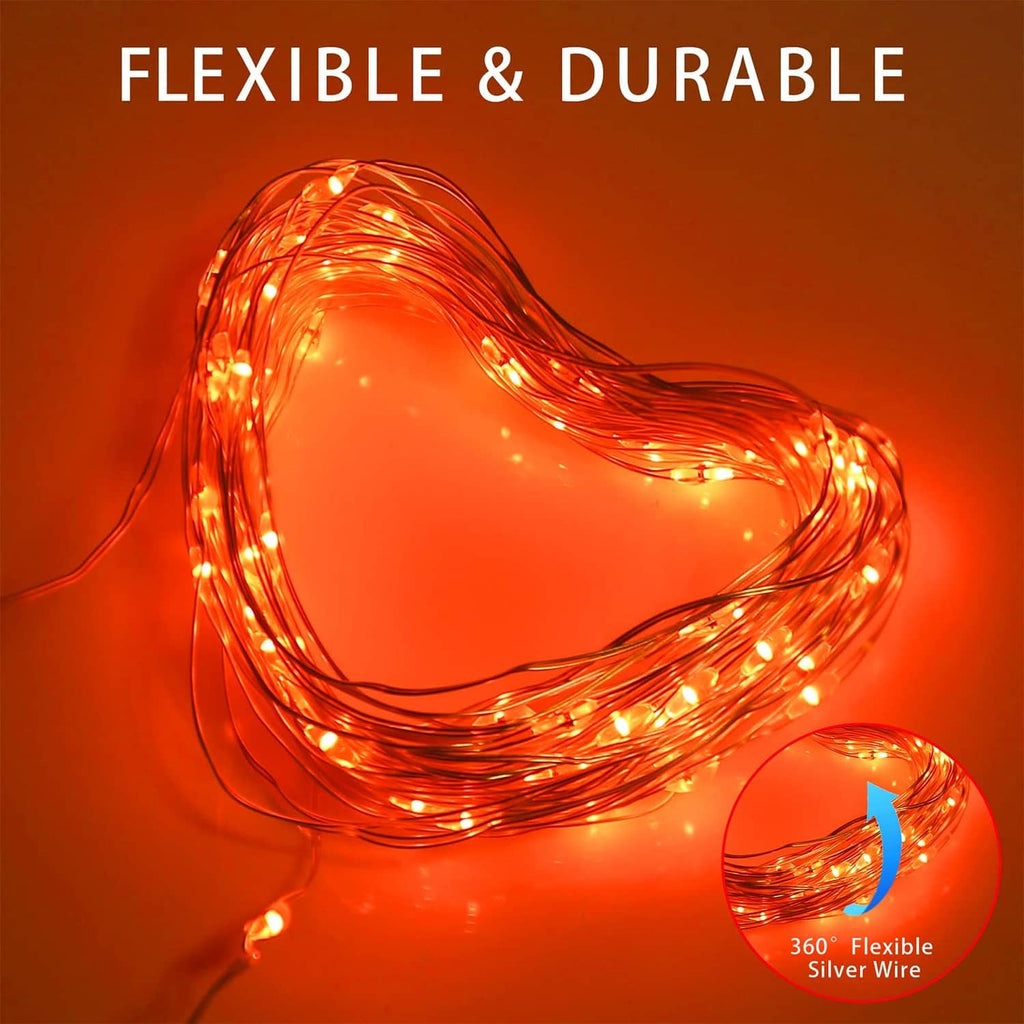 Copper wire solar string lights shaped into a heart with warm glowing bulbs