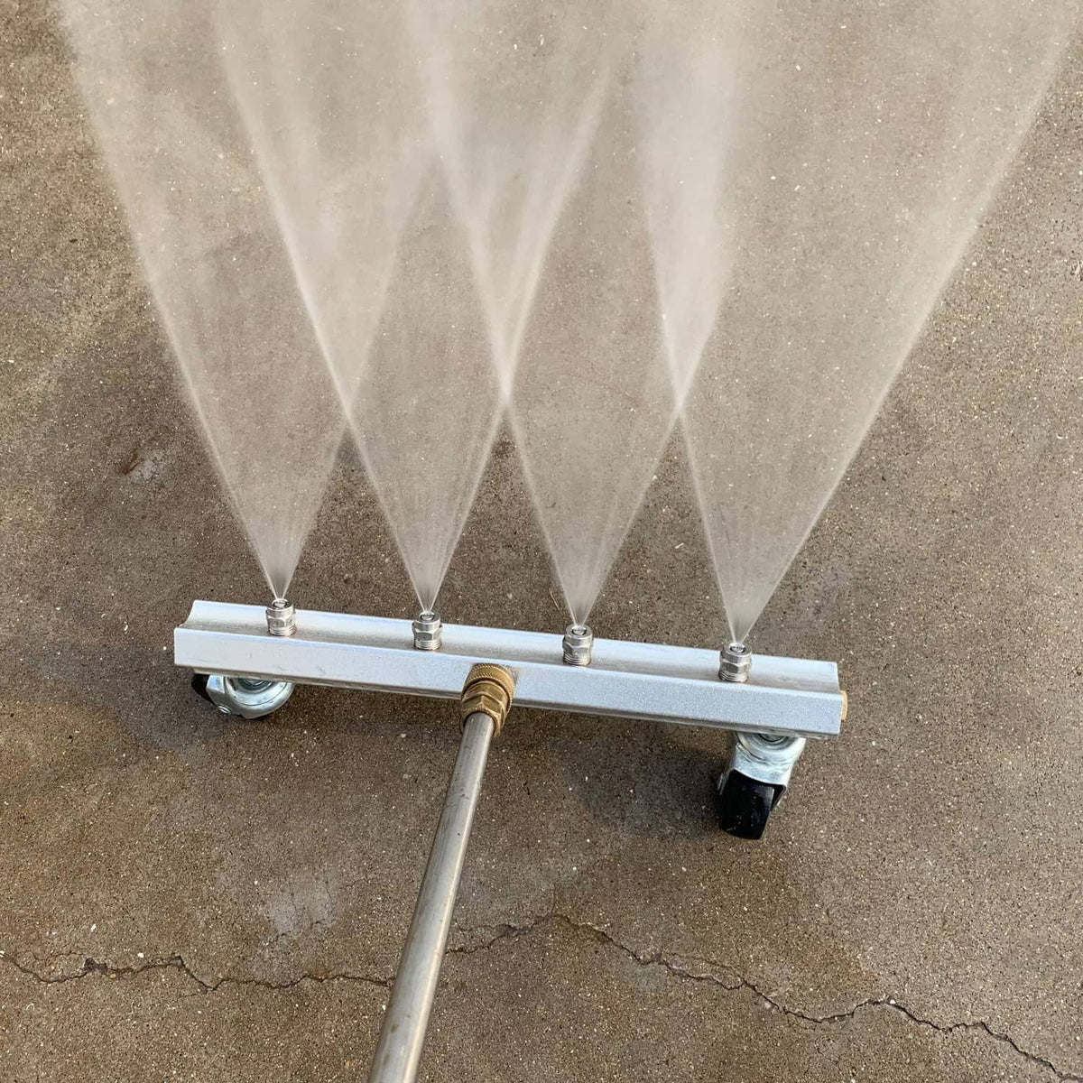Undercarriage pressure washer cleaner with spray fan pattern from multiple nozzles over ground