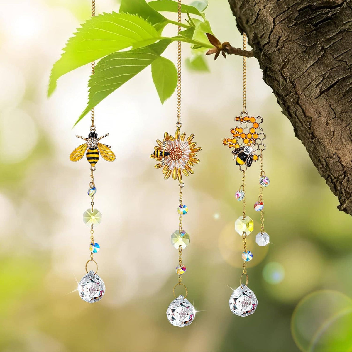 Three hanging gold crystal suncatchers: bee, sunburst flower, and honeycomb charm